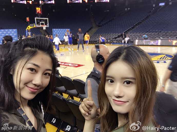 阳光洒在奥克兰的街头，李跑与特意赶来陪她追星的闺蜜在甲骨文球馆外留下了一张笑容灿烂的合影，背景是悬挂着总决赛旗帜的场馆外墙，大战前的期待感扑面而来。