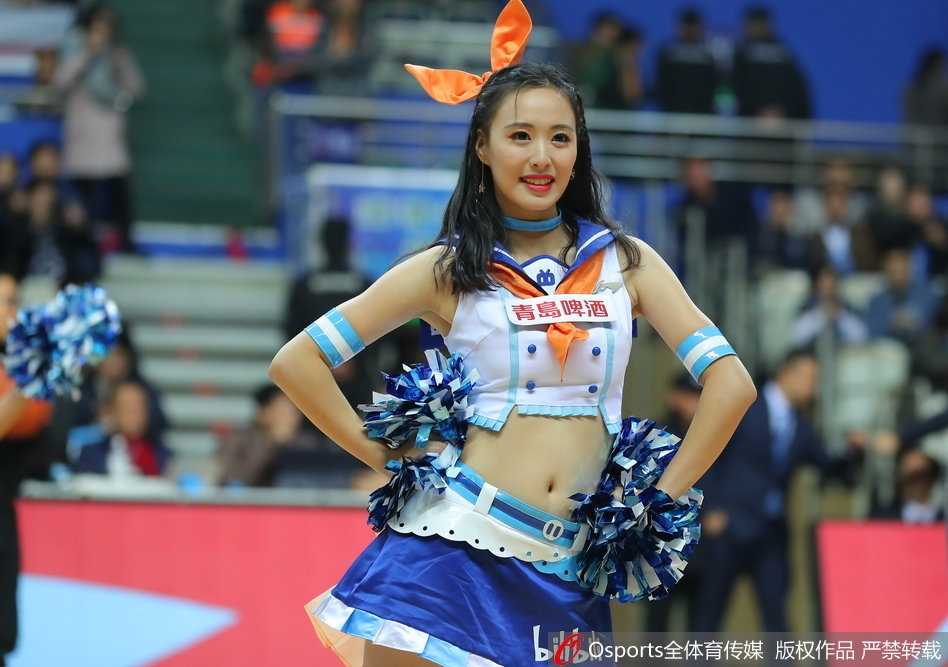 在灯光聚焦的舞台上，一位篮球宝贝马尾高束，眼神坚定地看向远方，充满力量感的舞蹈动作与身后拼搏的球员剪影遥相呼应。